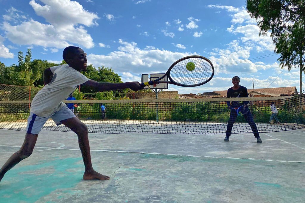 Due ragazzini giocano a tennis in una casa d'accoglienza a Ndola (Zambia): l'obiettivo della campagna è regalare alla struttura un campo regolamentare