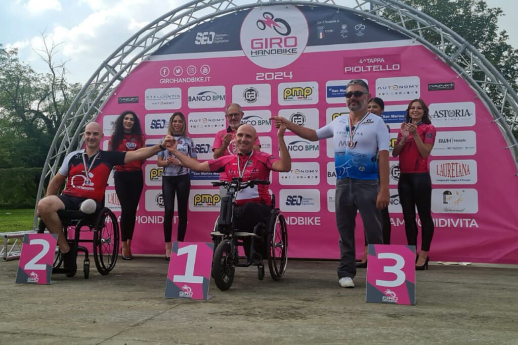 Mirko De Cortes (al centro) premiato per il successo nella quarta tappa del Giro Handbike